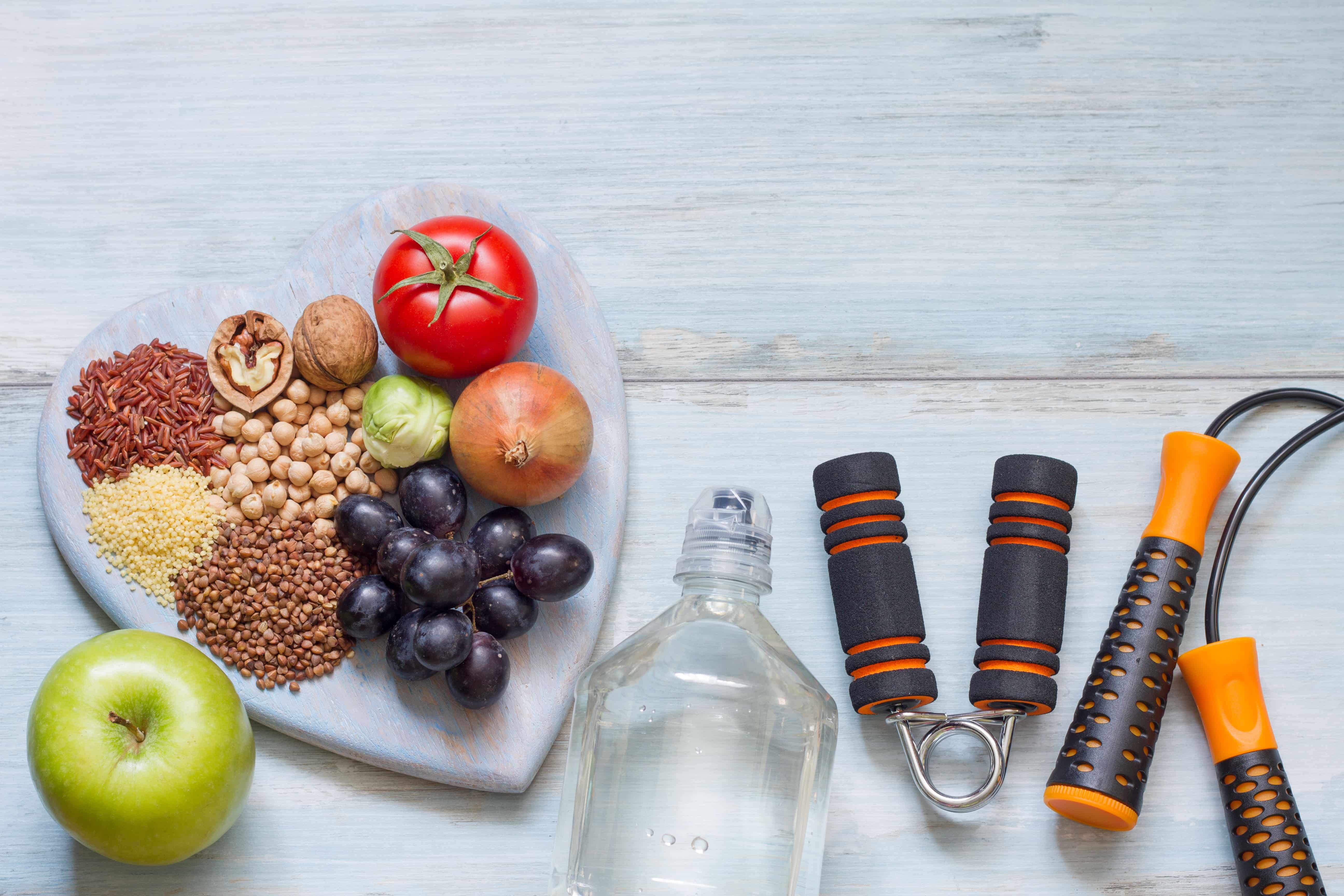 healthy fat loss tools including fruit, water, nuts, and exercise equipment