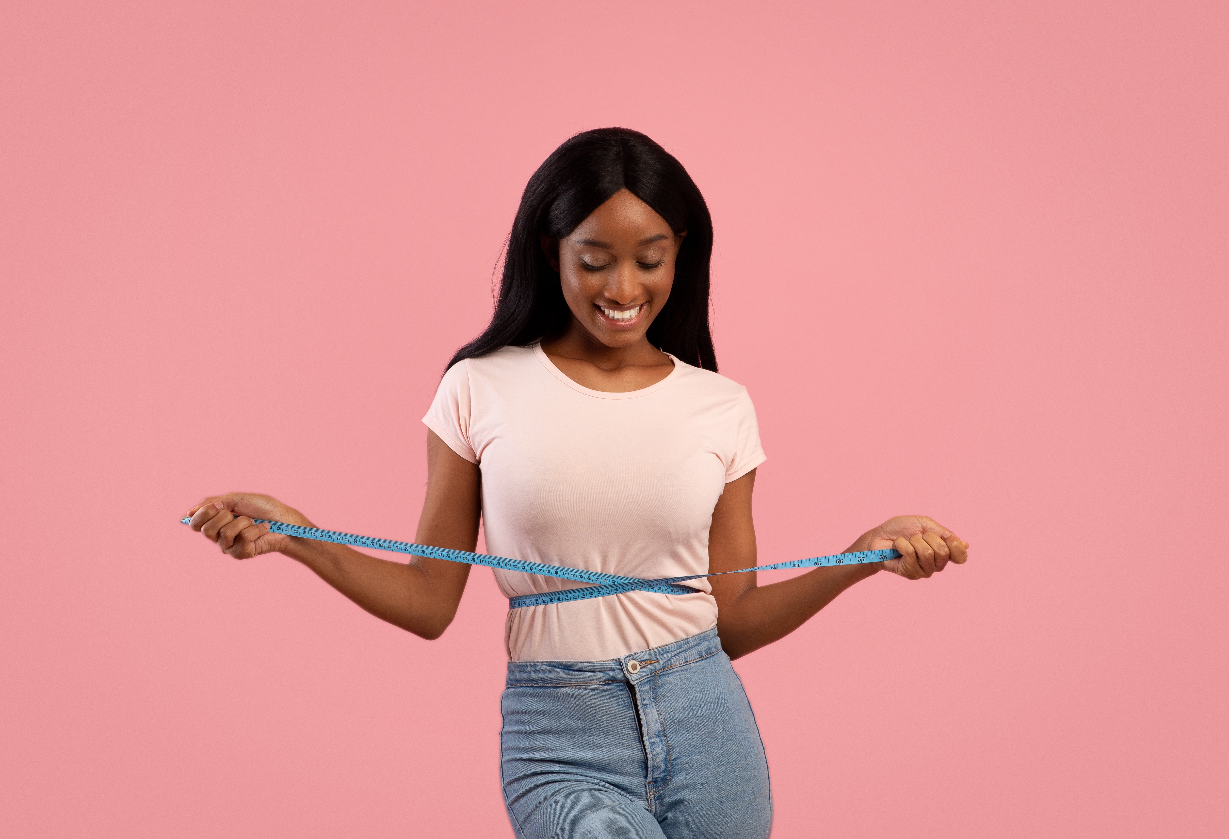 girl measuring reduced belly fat