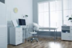 Diffused image of an empty patient room at a clinic.