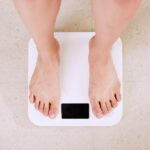 Person standing on a digital body weight scale during a weight loss measurement