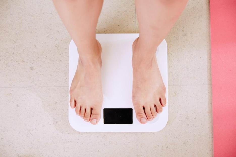 Person standing on a digital body weight scale during a weight loss measurement